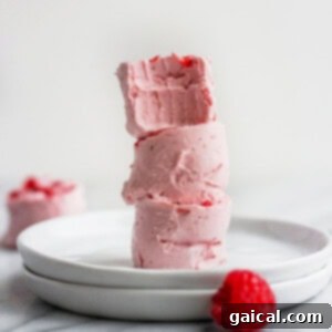 A stack of raspberry fat bombs on a white plate, highlighting a perfect keto dessert.