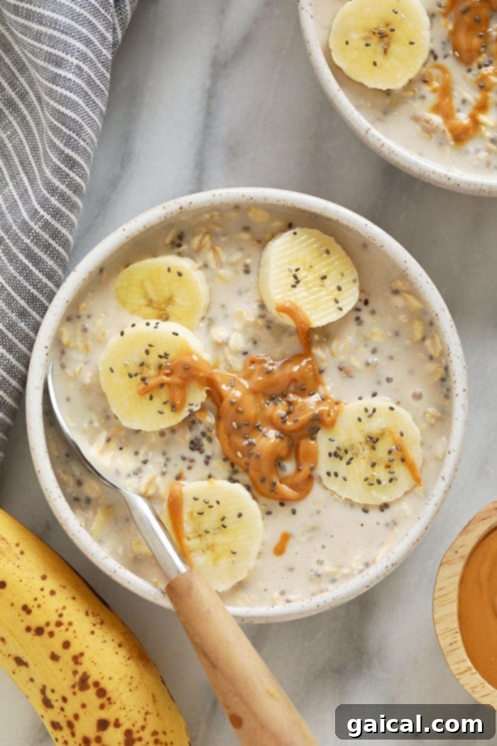 With mashed bananas and Greek yogurt, these Creamy Banana Overnight Oats are the perfect start to the day! Make a batch of these overnight oats today, and enjoy for breakfast all week long. This healthy overnight oats recipe is calling your name! Creamy banana overnight oats served in a bowl, garnished with fresh banana slices and a sprinkle of chia seeds.