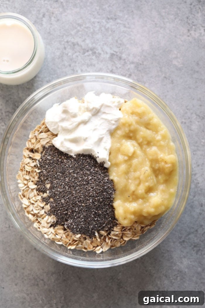 With mashed bananas and Greek yogurt, these Creamy Banana Overnight Oats are the perfect start to the day! Make a batch of these overnight oats today, and enjoy for breakfast all week long. This healthy overnight oats recipe is calling your name! All the ingredients for creamy banana overnight oats laid out in a bowl, ready to be mixed.