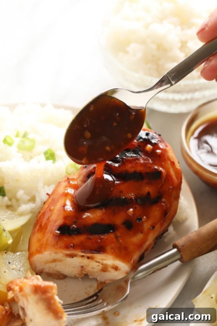 Teriyaki sauce drizzled over chicken, showcasing its glossy texture and rich color.