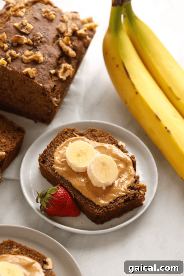 Delicious vegan banana bread slice topped with nut butter, ready to be enjoyed.