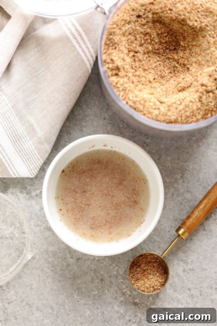 A close-up view of finely ground flaxseed meal in a small bowl, showcasing its powdery texture, ready for mixing with water.