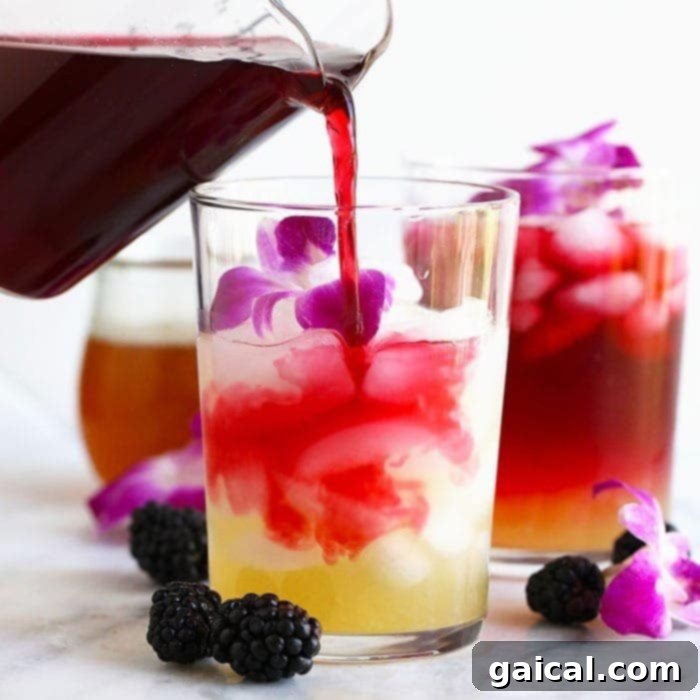 Over 15 Incredible Vodka Cocktail Recipes 3 Refreshing Hibiscus Arnold Palmer drink being poured into a tall glass with ice, showcasing its beautiful color.