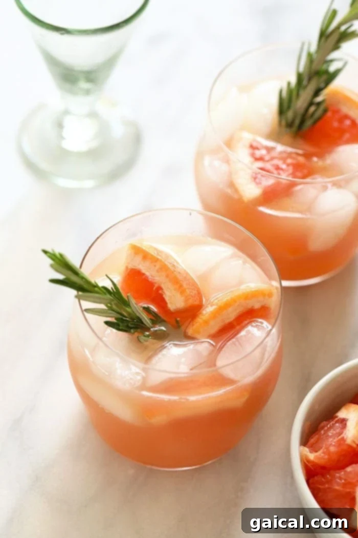 Golden Greyhound 5 Two elegant Honey Greyhound Cocktails, garnished with fresh rosemary sprigs, ready to be served.