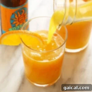 Hoppy Sunrise 4 A vibrant Beermosa cocktail with orange juice being poured into a glass, highlighting the simple preparation.
