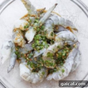 Shrimp Infusion Perfection 5 Grilled prawns in a glass bowl soaking in the marinade with fresh herbs.