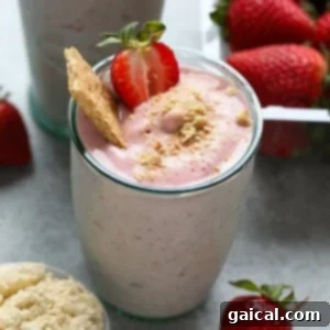 A glass of Strawberry Protein Shake garnished with a strawberry slice.