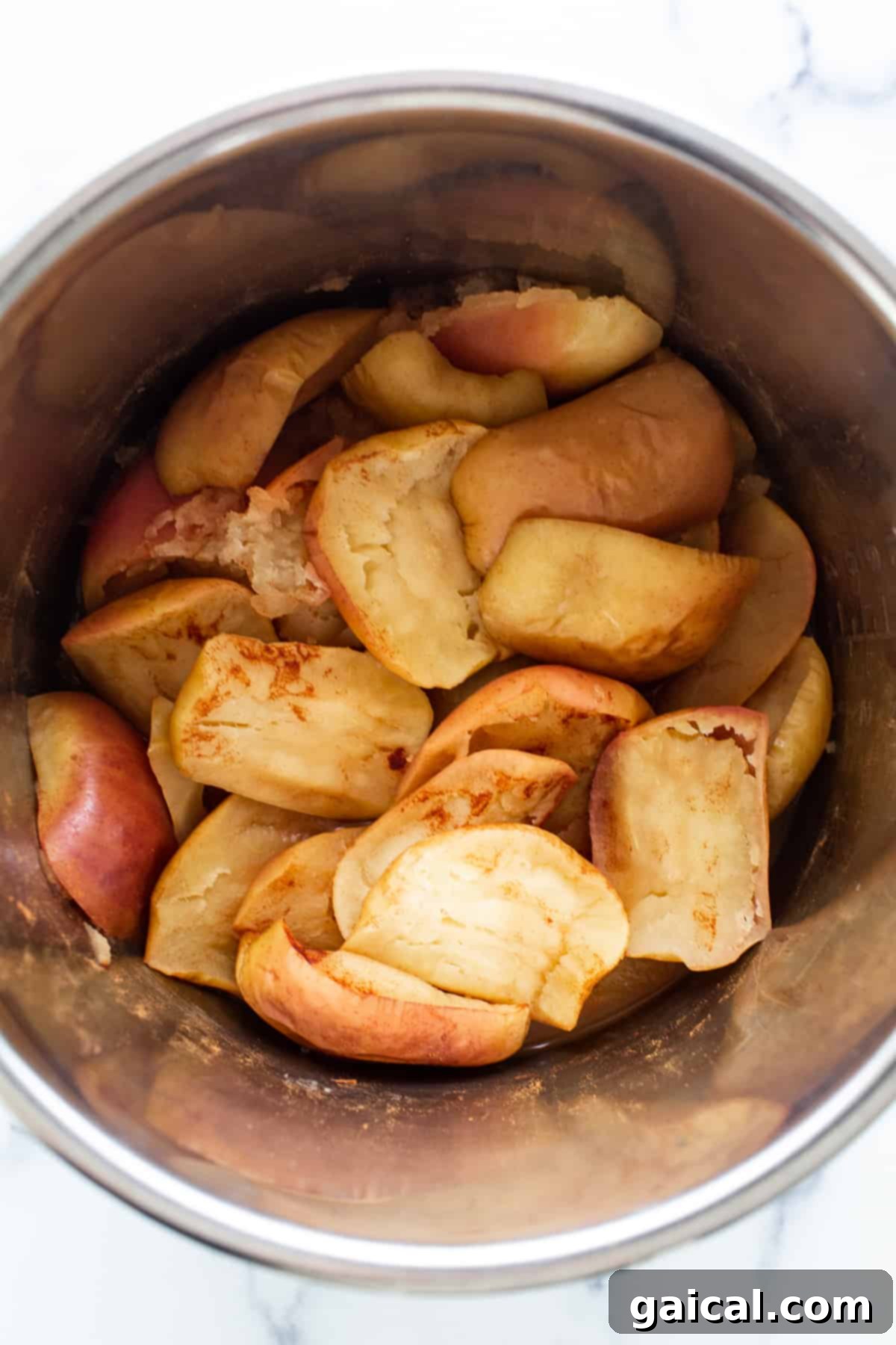 Easy Homemade Instant Pot Applesauce 4 Close-up of freshly cooked apples being blended in an Instant Pot with an immersion blender, showcasing the transformation into smooth applesauce.