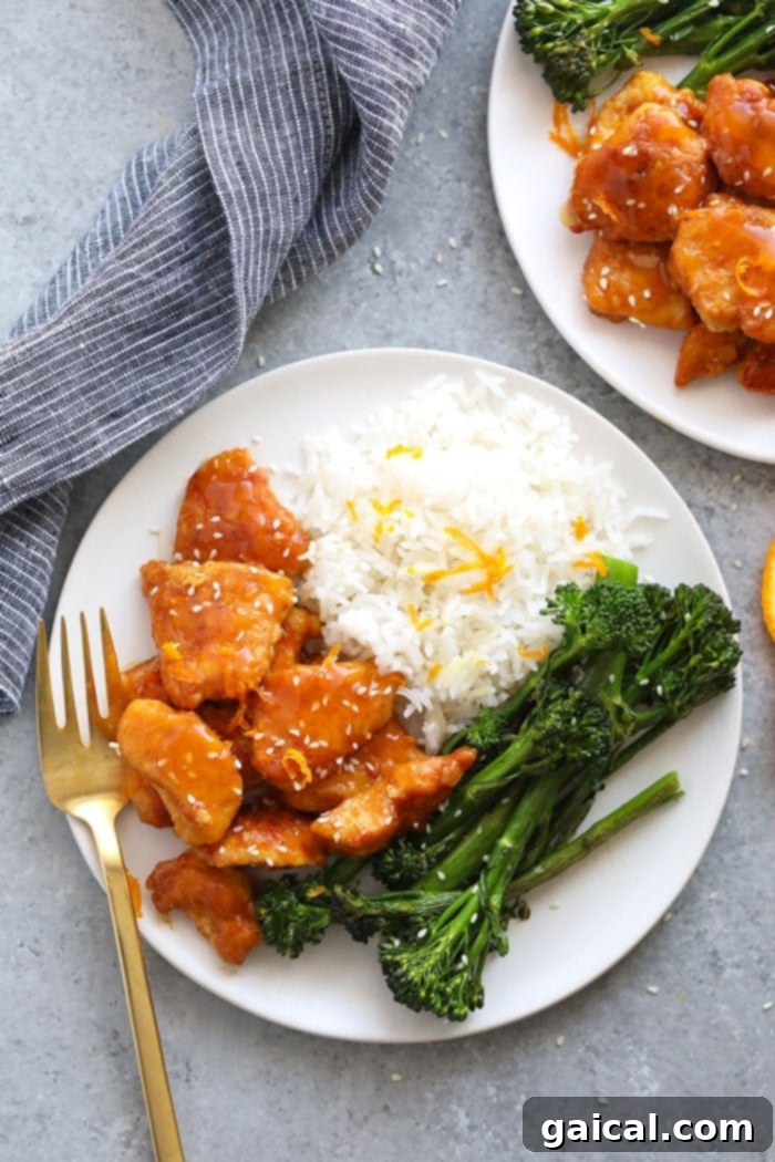 Delicious and healthy homemade orange chicken served in a bowl, garnished with sesame seeds and green onions.