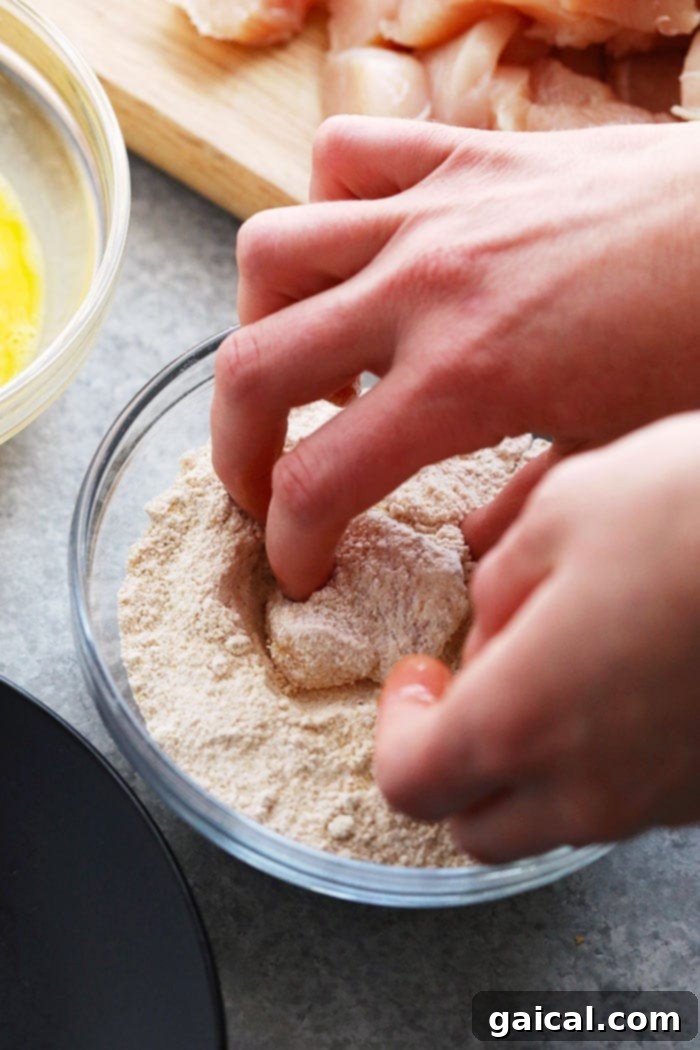 Raw chicken pieces coated in a seasoned flour mixture, ready for cooking.