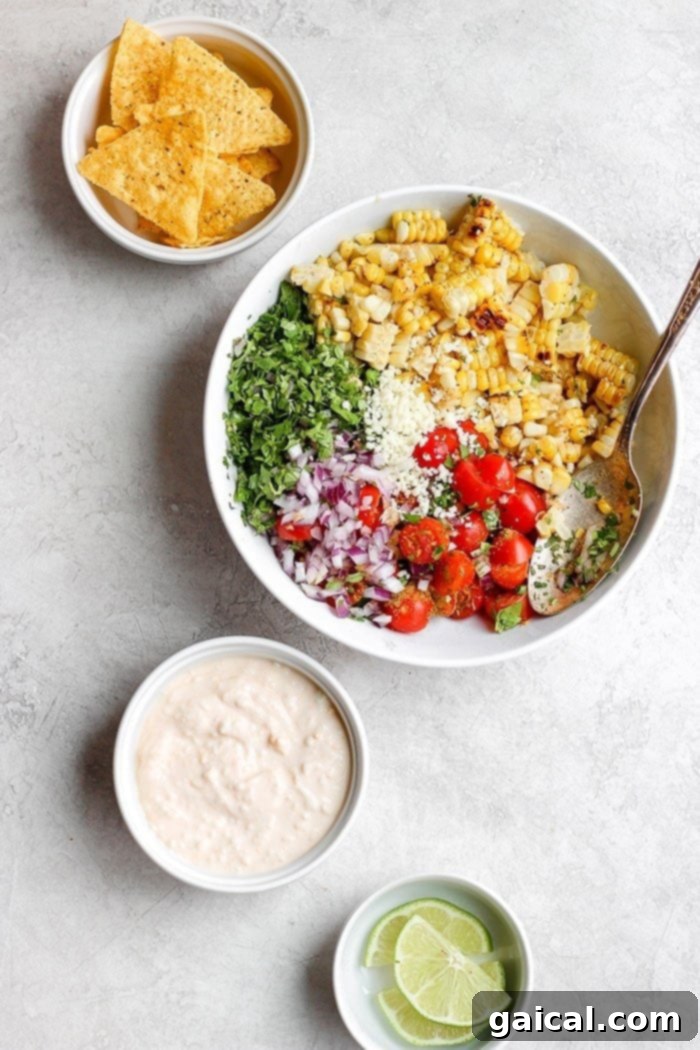 This Mexican Street Corn Salad is made with fresh ingredients and a delicious Greek yogurt sauce for a healthy and flavorful side. A second view of the Mexican Street Corn Salad in a bowl, showcasing its fresh ingredients and creamy Greek yogurt sauce.