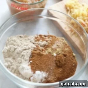 The ingredients for apple cinnamon pancakes are in a bowl next to a measuring cup with bread.