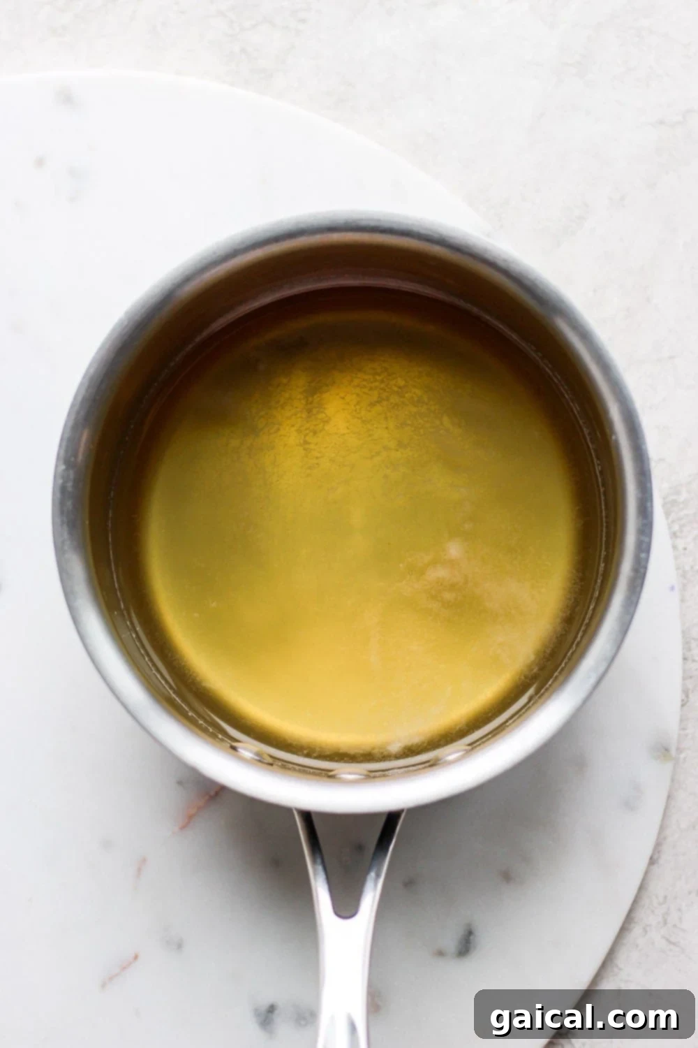 Honey simple syrup cooling in a glass jar. Close-up of golden honey simple syrup being poured into a glass jar after preparation.