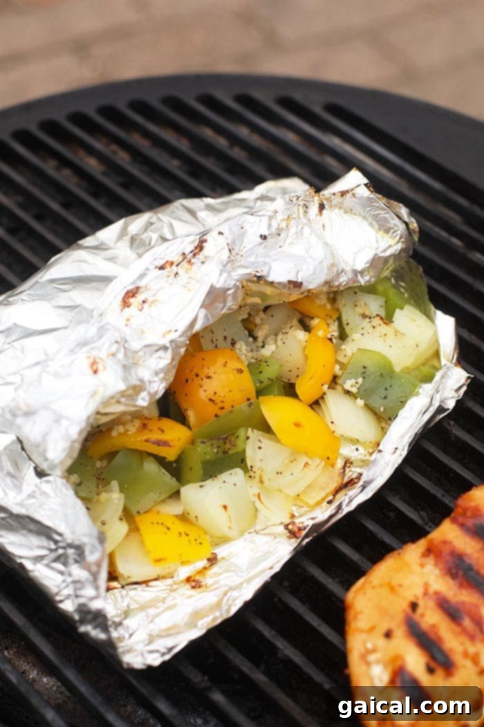 v peppers and onions in foil pack on grill, ready to be cooked