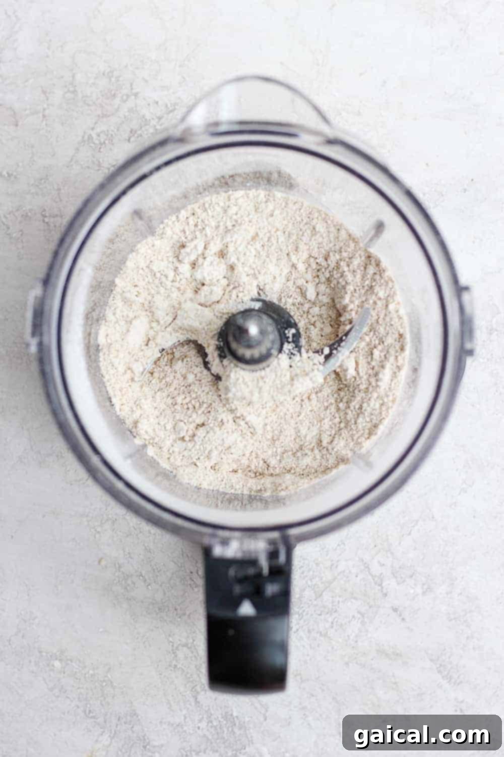 Making Oat Flour for Your Healthy Cookie Dough Bites Rolled oats being transformed into fine oat flour in a high-speed food processor, a key step for smooth cookie dough energy bites.