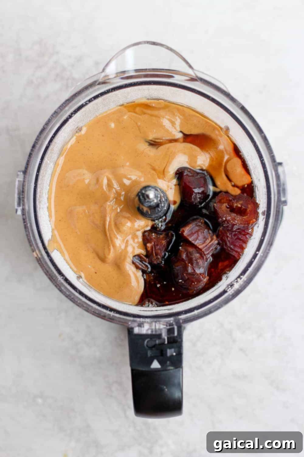 Combining Ingredients in a Food Processor for Energy Bites All the wholesome ingredients for healthy cookie dough bites being added to a food processor before blending.
