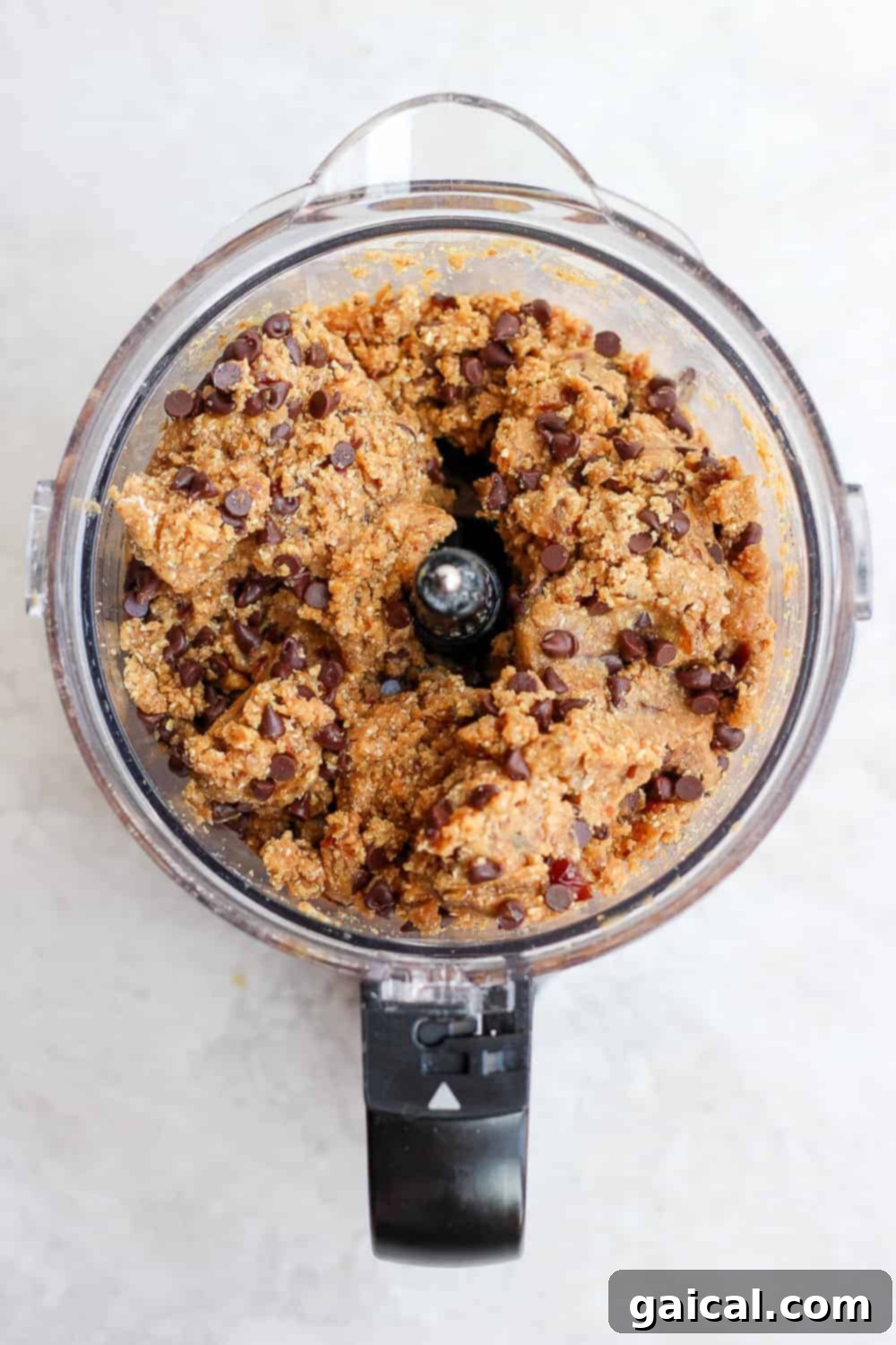 Achieving Perfect Cookie Dough Texture in Your Food Processor Healthy cookie dough mixture actively being processed in a food processor, transforming into a smooth, cohesive dough.