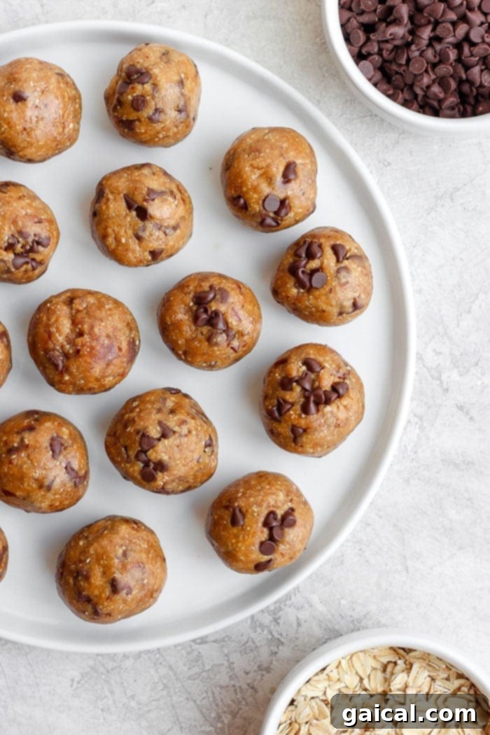 Perfectly Formed No-Bake Cookie Dough Energy Bites Freshly made cookie dough energy balls stacked on a plate, garnished with a sprinkle of sea salt.