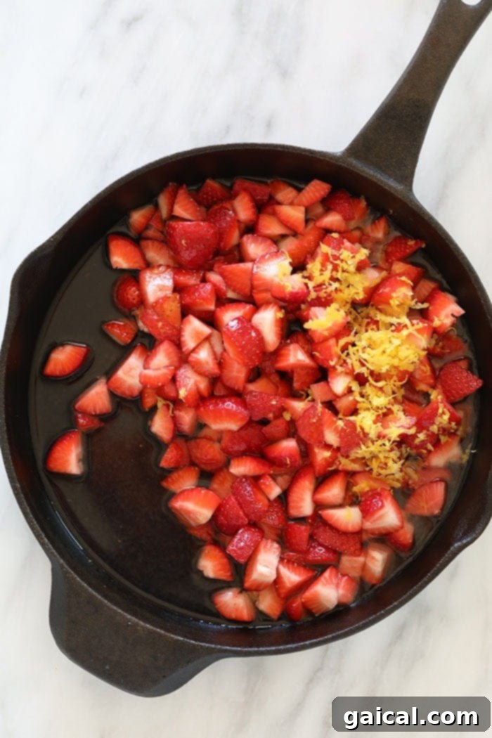 These Strawberry Oatmeal Bars are your summer dessert dreams come true! With an easy to make crust and crumble topping, and a filling made of sliced fresh strawberries reduced to perfection (with no added sugar!), these oatmeal bars are the best strawberry dessert to enjoy all summer long! Enjoy! Finely sliced fresh strawberries simmering in a cast iron skillet with other ingredients, ready to be reduced into a luscious filling.
