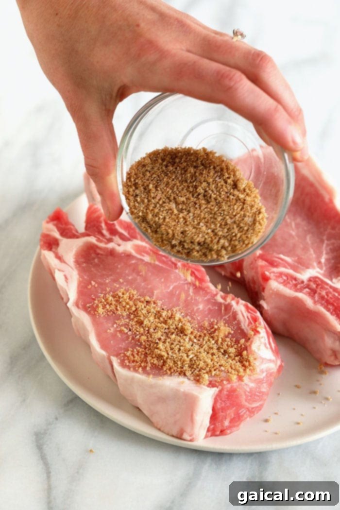 Applying dry rub to pork chops before cooking