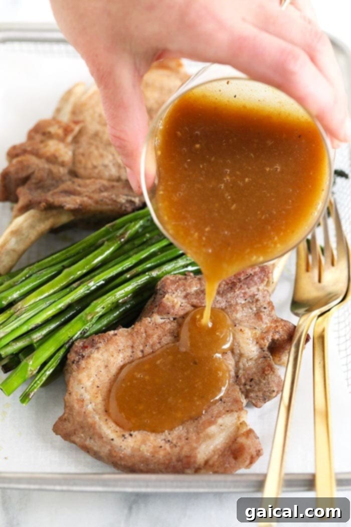 Pouring rich whiskey gravy over Instant Pot pork chops