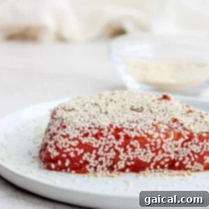 A piece of seared ahi tuna with sesame seeds on a plate.