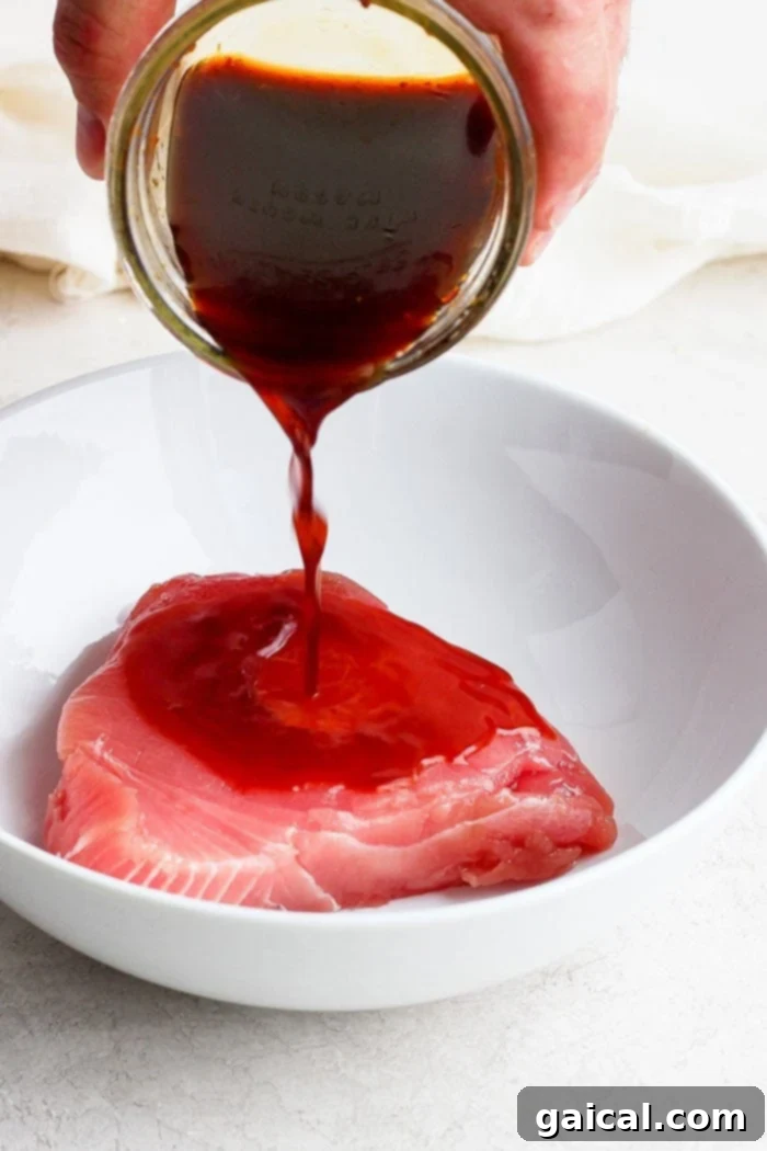 Pouring marinade over ahi tuna steaks