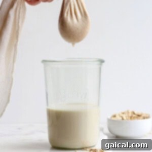 Craft Your Own Oat Milk 7 Gently squeezing a tea towel to extract the last drops of creamy oat milk from the remaining oat pulp.