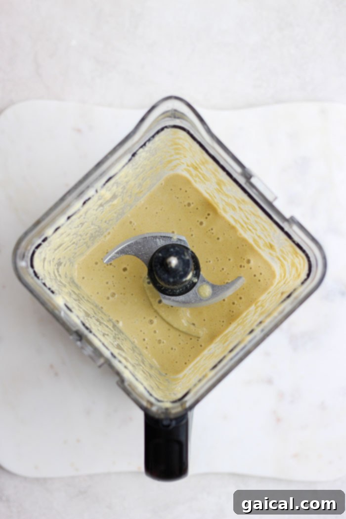 Smooth, rich cashew cream sauce being blended in a high-speed blender, ready for the curry.