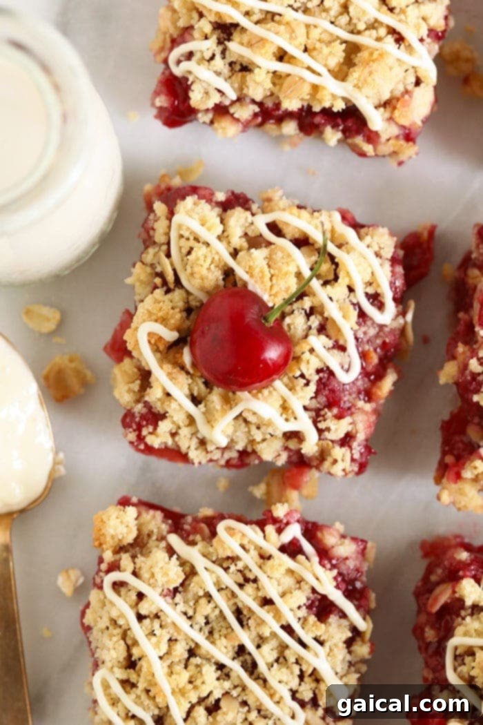 Serve these beautiful bars chilled for the best texture and flavor. Perfectly sliced cherry cobbler bars, drizzled with a creamy glaze, on a white plate next to a glass of milk.