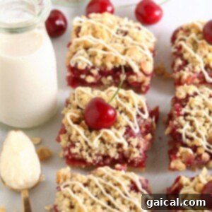Cherry cobbler bars on a white plate with a glass of milk.