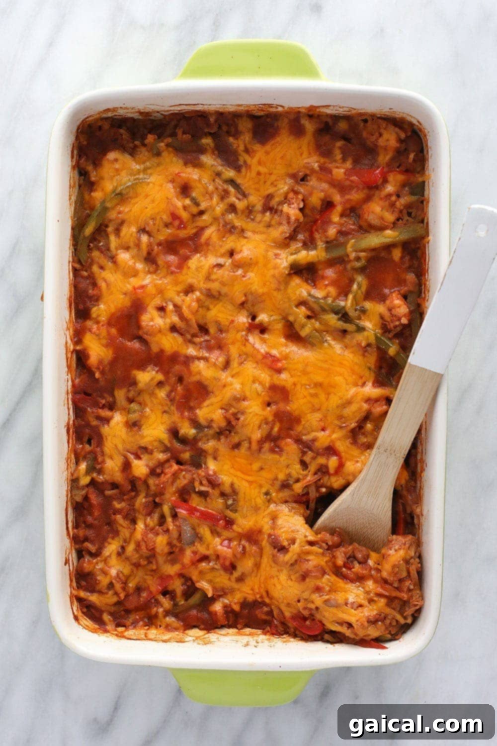 This healthy chicken burrito bowl casserole is made with ground chicken, beans, rice, Mexican spices, and all the topping for a delicious one-pot dinner the entire family will enjoy! Chicken burrito bowl casserole in a serving bowl