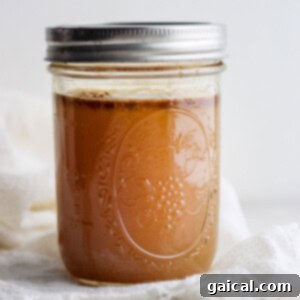 A pot of rich, golden homemade chicken broth.