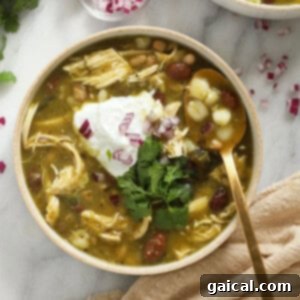 A vibrant bowl of green chicken chili with fresh toppings.