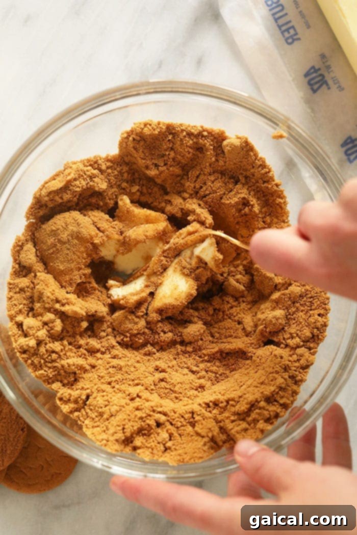 The initial steps of preparing the pumpkin cheesecake bars, showing the gingersnap cookie crust being mixed in a bowl.