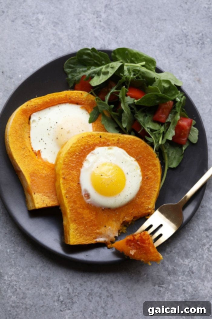 Butternut squash egg in a frame on a white plate, garnished with fresh herbs, ready for a healthy breakfast.