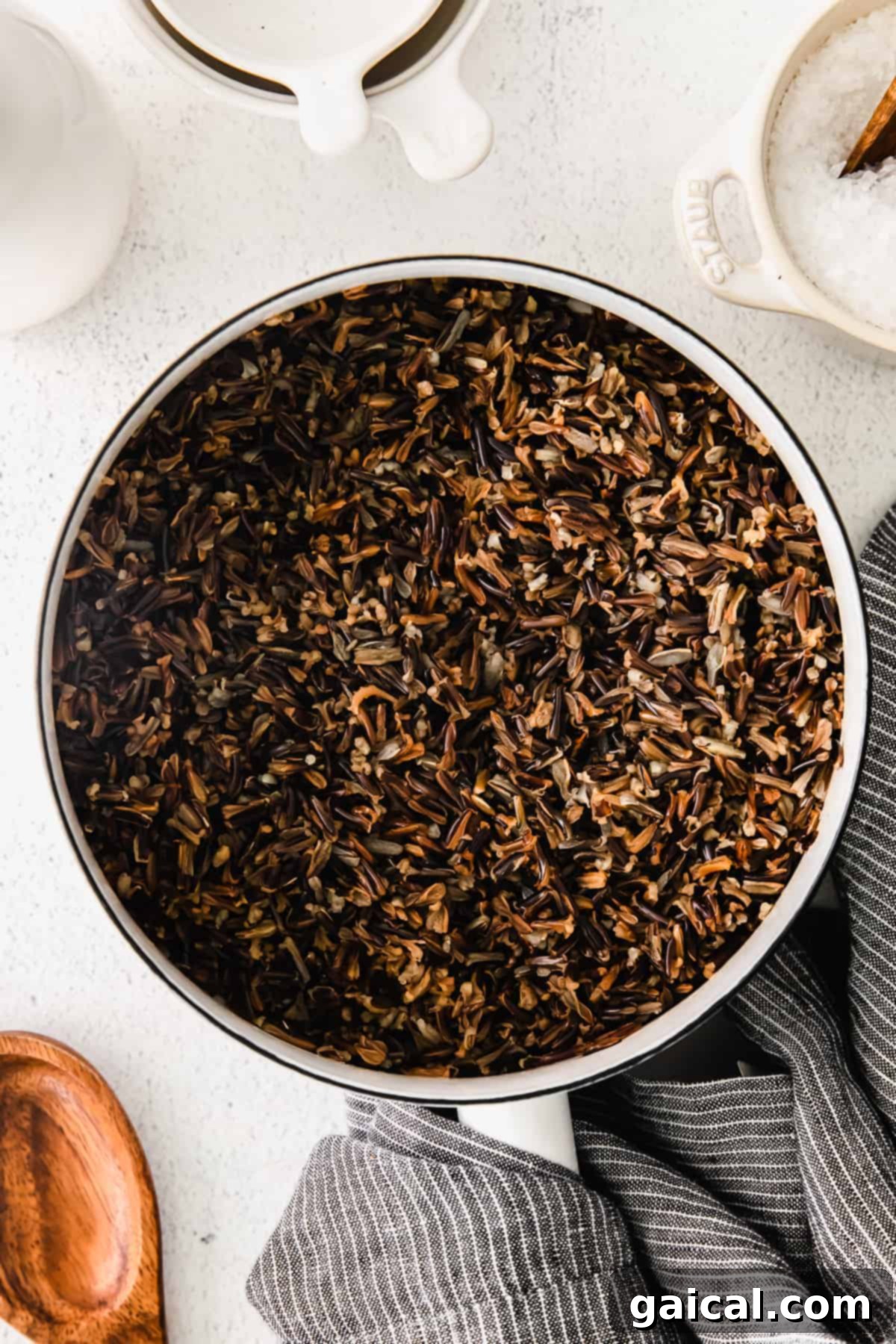 Wild rice is a great addition to so many meals! Check out how to make wild rice on the stove and in the Instant Pot. Both ways are easy and will have you using wild rice on a regular basis. A close-up of cooked wild rice in a stockpot, showing the perfectly separated and popped grains.