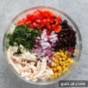 All the vibrant chicken salad ingredients mixed in a bowl before adding the dressing, showcasing the freshness.