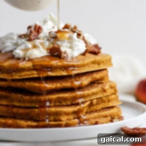 Dreamy Pumpkin Pancakes 7 A stack of fluffy pumpkin pancakes on a plate, ready to be served.