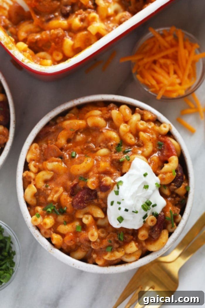 Chili mac and cheese: the ultimate comfort food for a kid-friendly, protein-packed family dinner. A comforting bowl of homemade Chili Mac and Cheese, garnished and ready to eat.