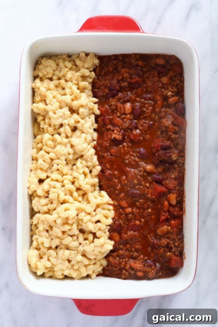 Golden-baked Chili Mac and Cheese: the ultimate family meal prep solution. A bubbling Chili Mac and Cheese casserole fresh from the oven, served in a ceramic baking dish.