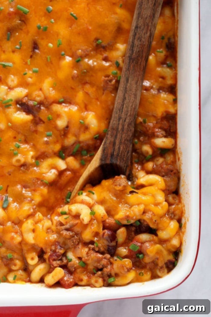 Hearty Chili Mac and Cheese: a warm and satisfying meal for any day. A large serving of Chili Mac and Cheese in a white bowl, ready to be enjoyed.