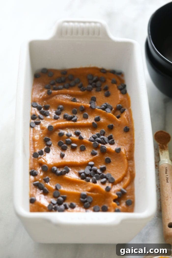 Spiced Pumpkin Nice Cream 5 Pumpkin pie banana nice cream packed into a bread loaf pan, topped with chocolate chips and ready for freezing.