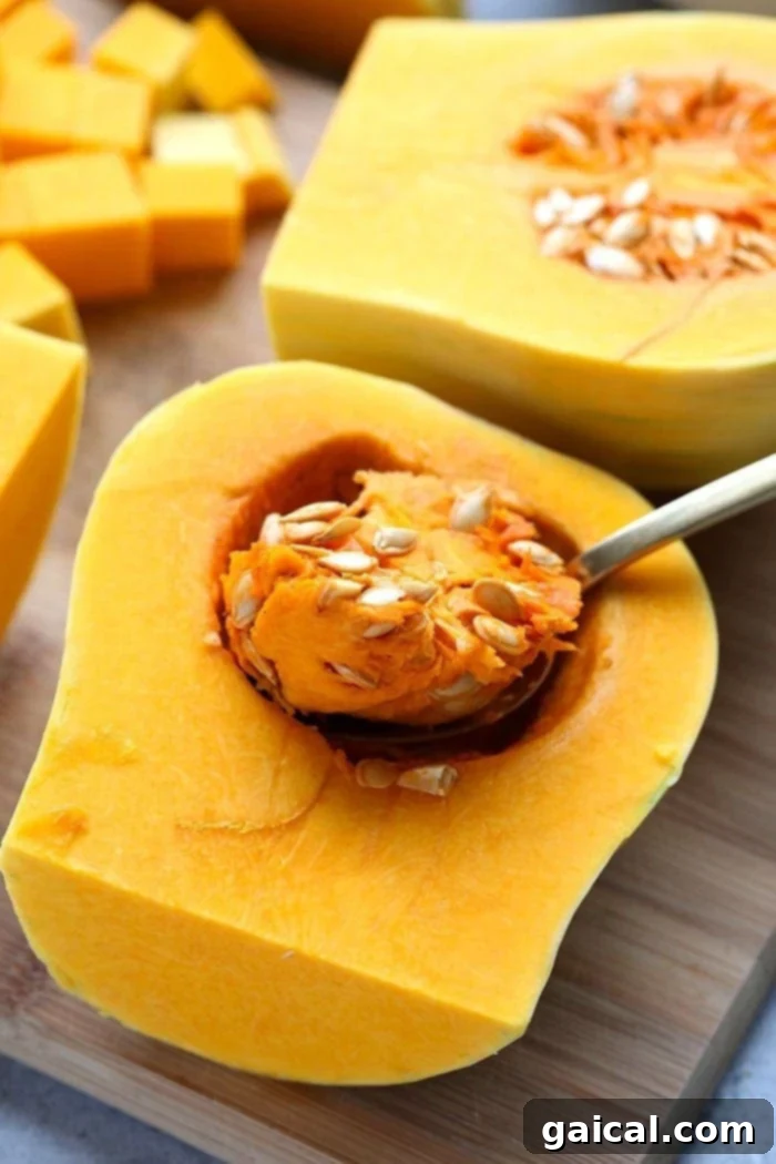 Effortless Butternut Squash Preparation: No Peeling Required for Instant Pot Soup A sharp chef's knife expertly quartering a butternut squash on a sturdy wooden cutting board, demonstrating the simplified prep method for Instant Pot soup.