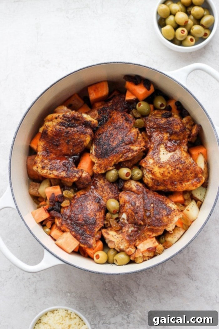 Hearty One-Pot Moroccan Chicken with Vegetables Rich and vibrant Moroccan chicken stew cooking in a rustic Dutch oven, garnished with fresh herbs.