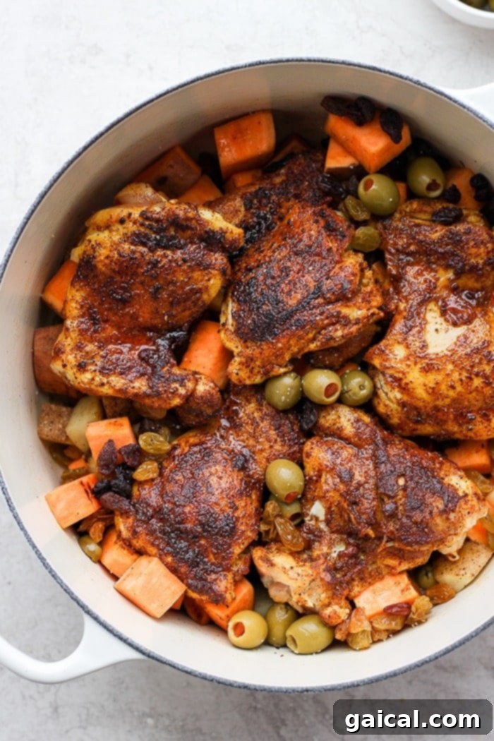Moroccan Chicken Stew in a Dutch Oven A flavorful One-Pot Moroccan Chicken stew, bubbling in a red Dutch oven, garnished with fresh cilantro.