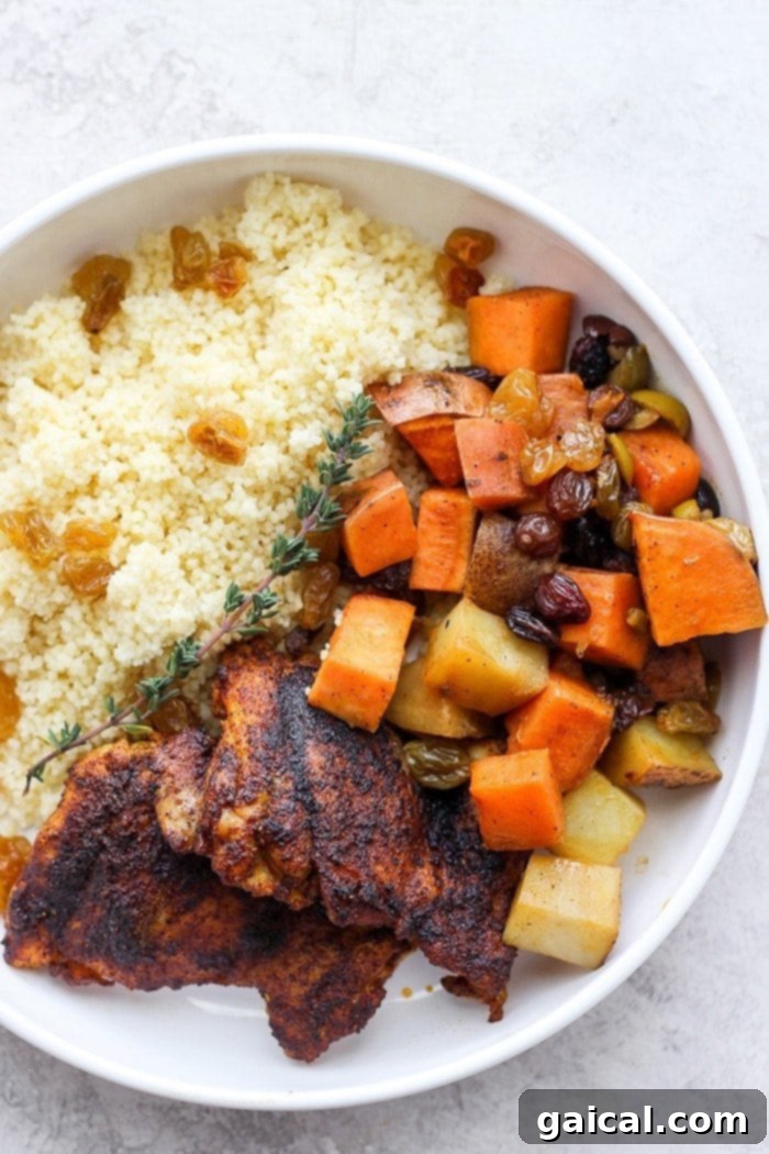 Moroccan Chicken Plated with Couscous and Vegetables A plate of hearty Moroccan chicken served over fluffy couscous with a medley of colorful vegetables and herbs.