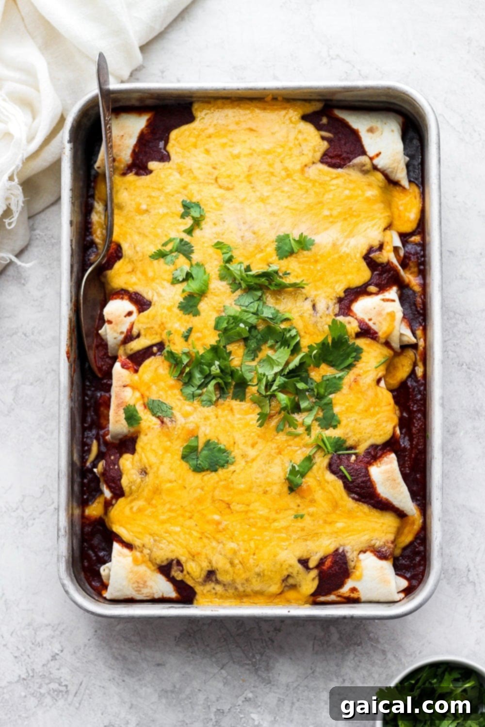 Rotisserie Chicken Enchilada Bake 2 A baking dish filled with golden-brown rotisserie chicken enchiladas, generously covered in melted cheese, ready to serve.