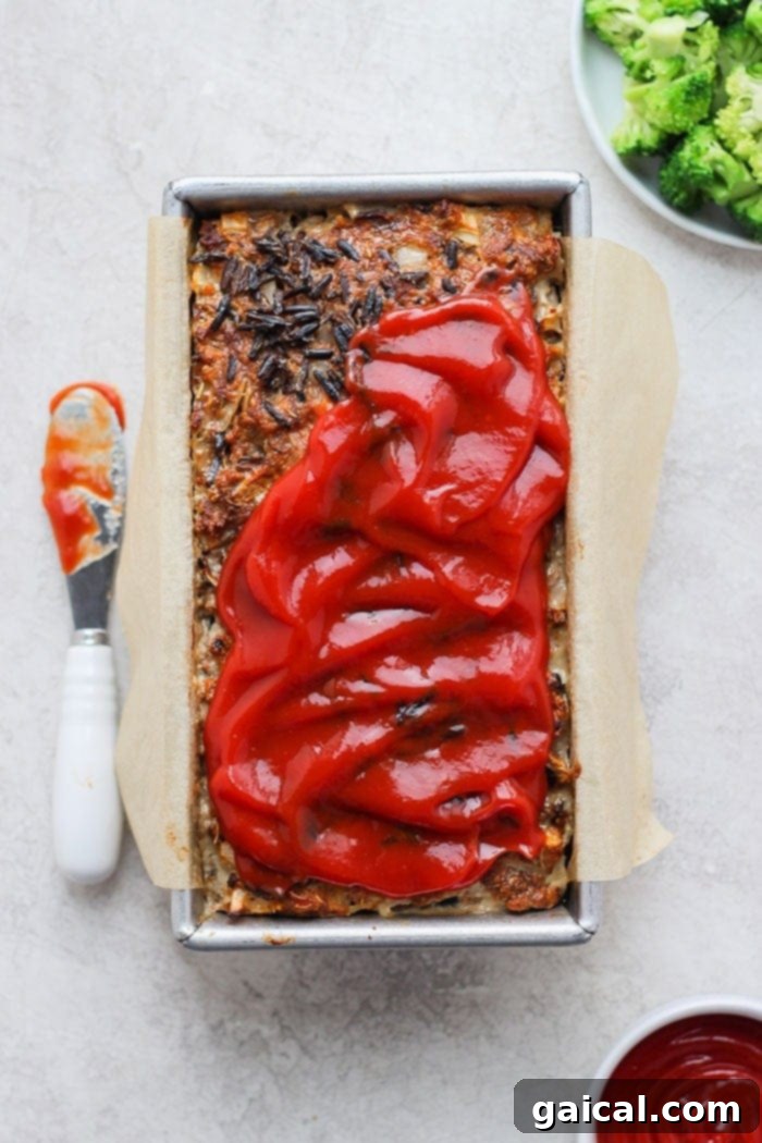 A delicious Wild Rice Meatloaf, baked to golden perfection in a loaf pan, garnished and ready to be served for a cozy dinner.