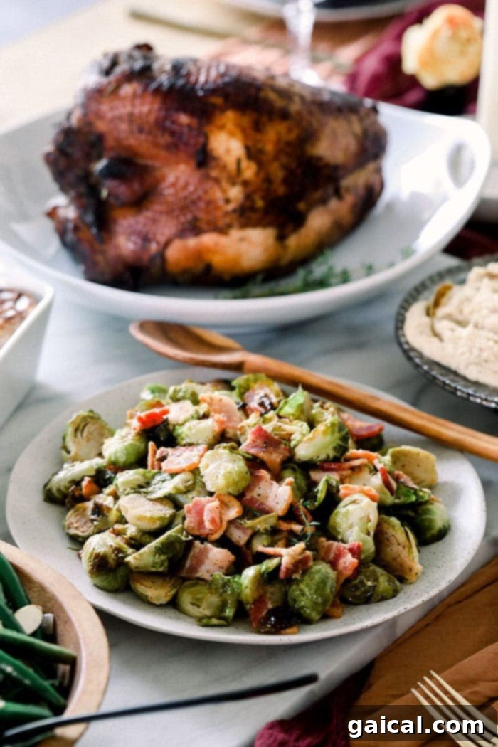 Roasted Brussels Sprouts with Crispy Bacon 9 A bowl of roasted Brussels sprouts with bacon on a rustic table, next to a carved turkey.